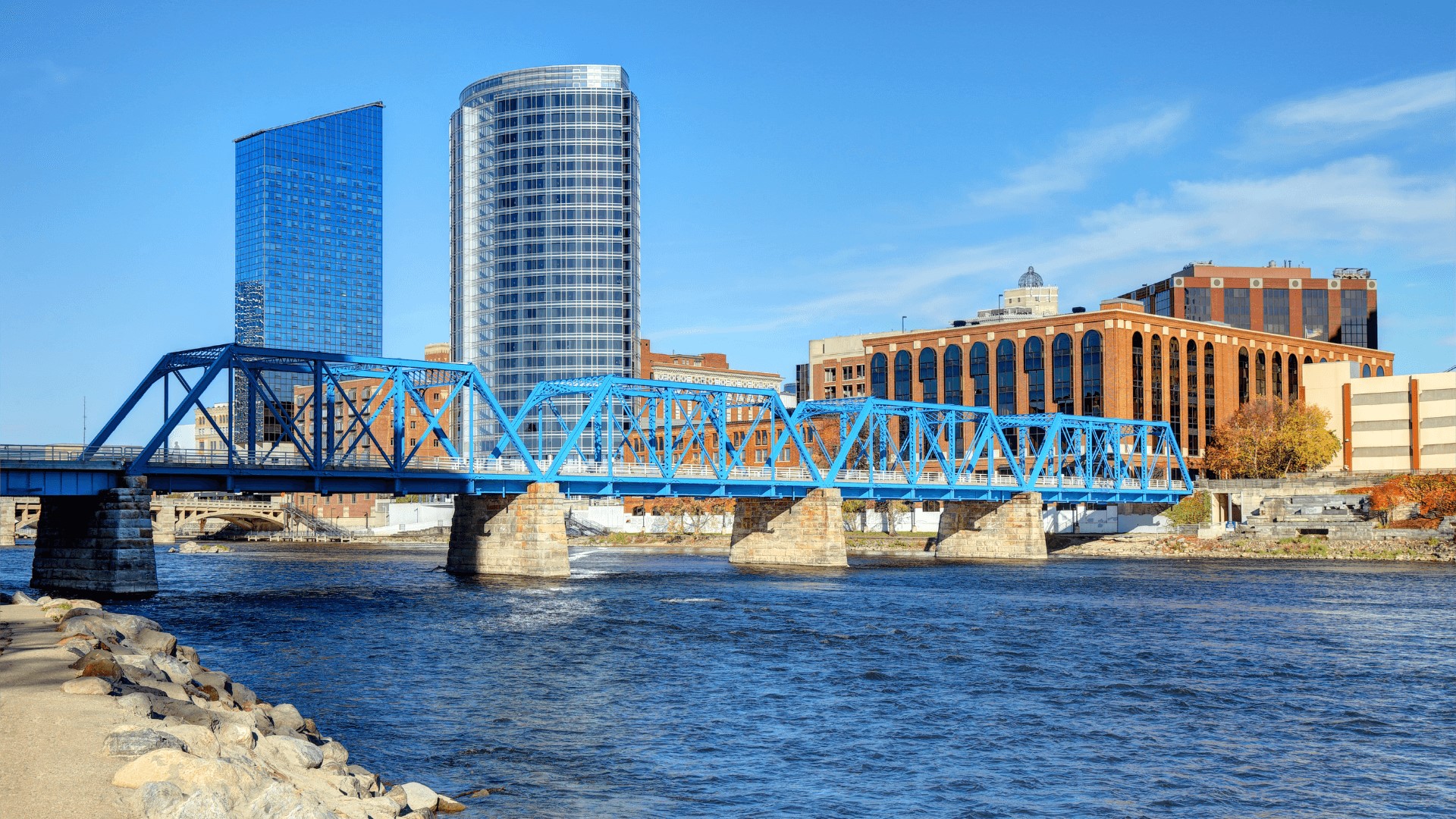 a blue bridge over a river in grand rapids