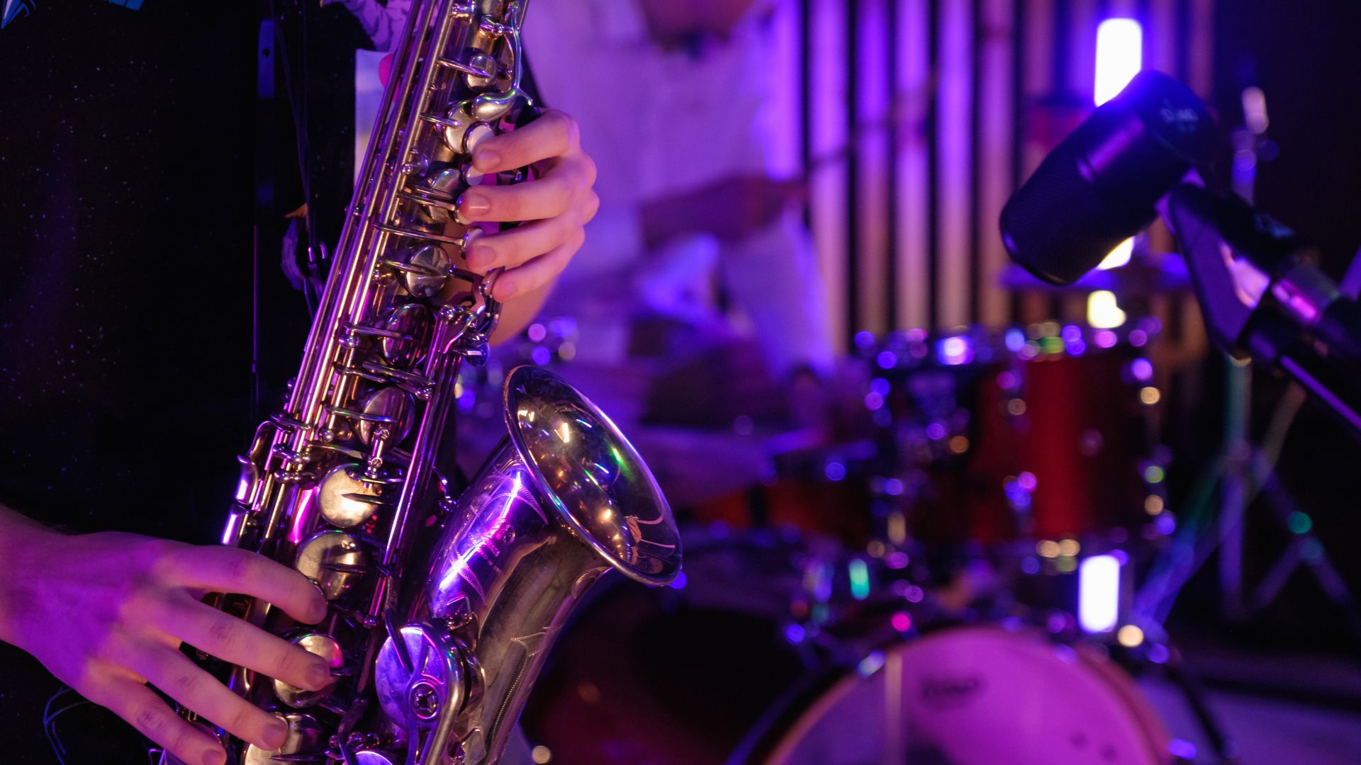 a person playing a saxophone in front of a band