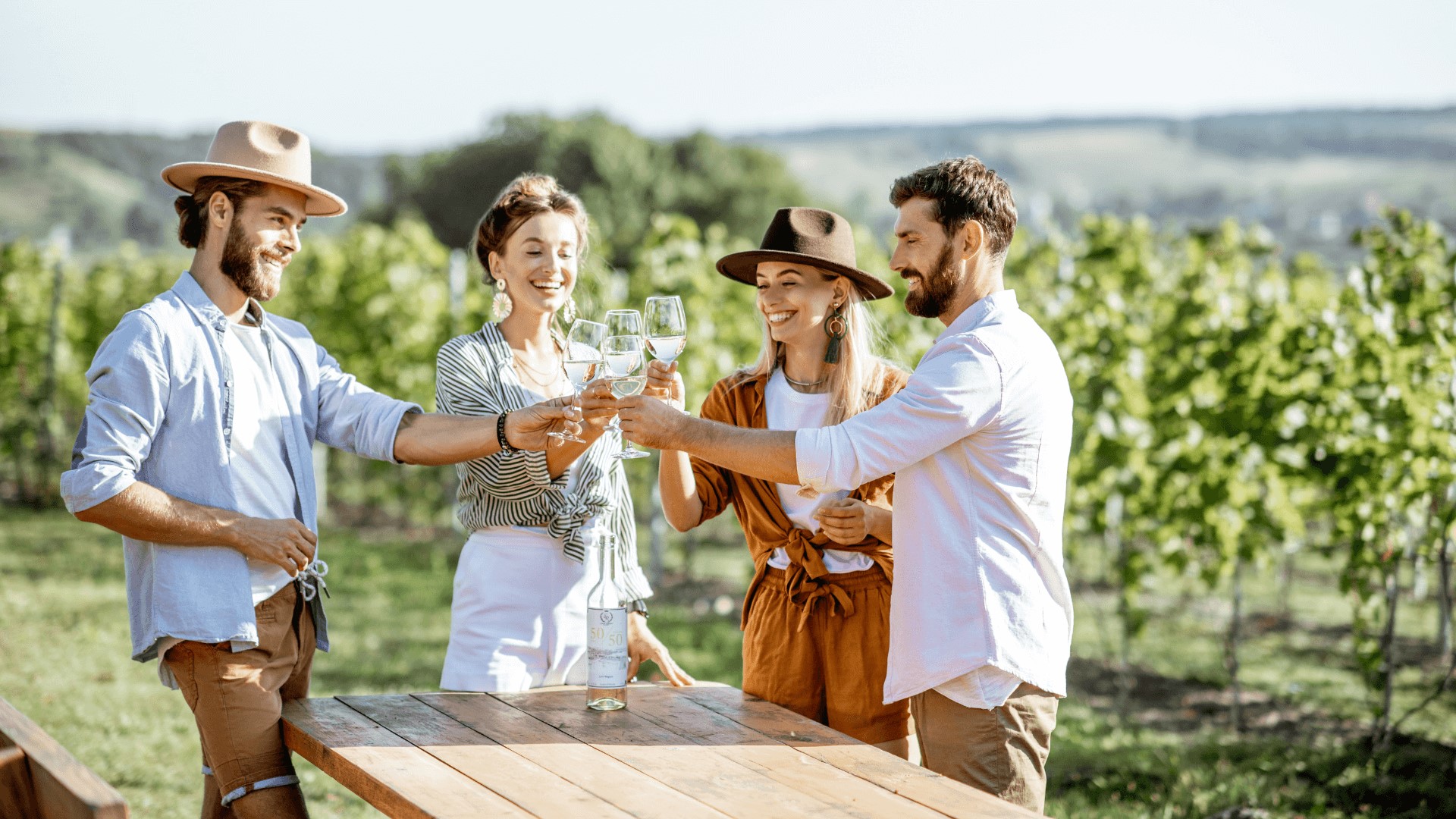 a group of friends toasting wine in a vineyard