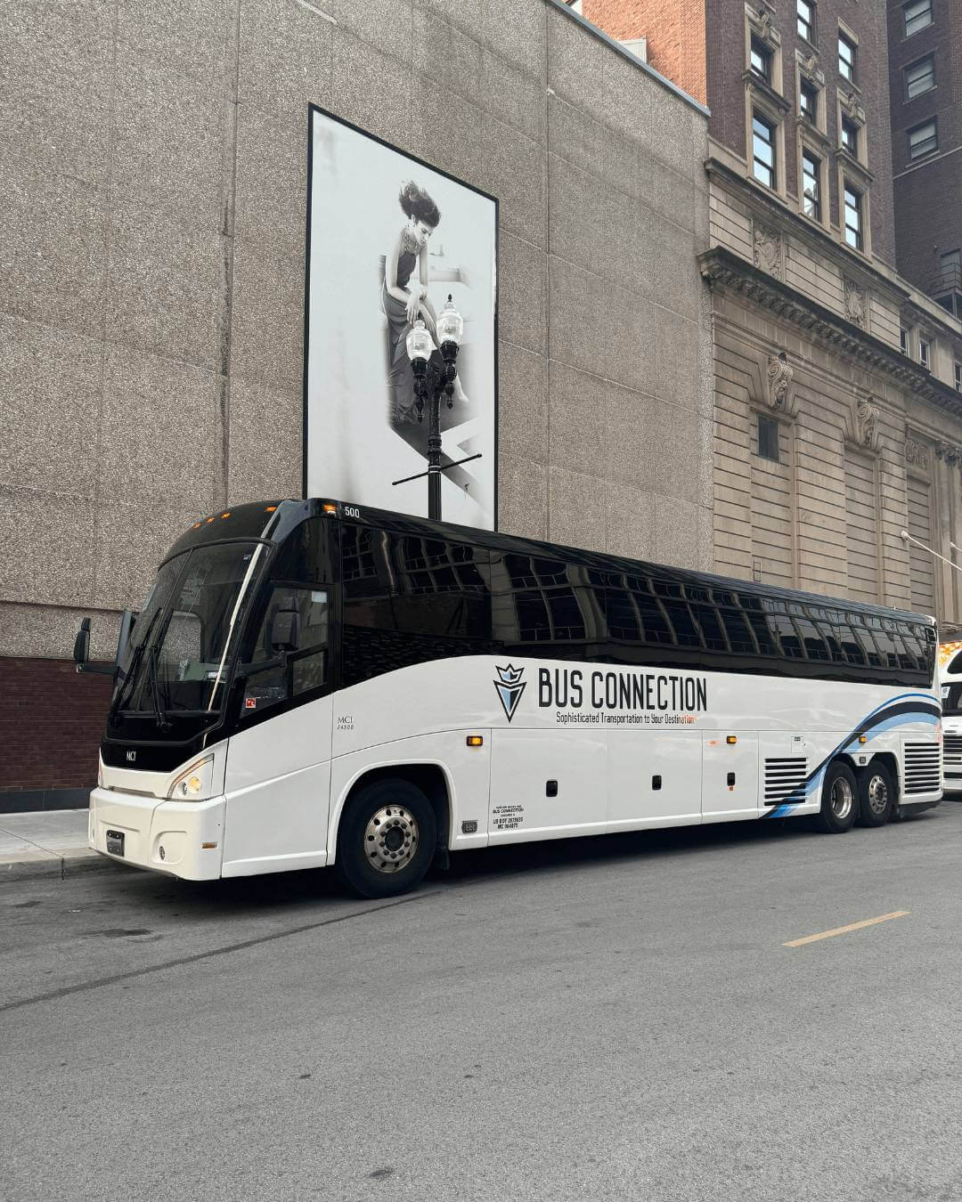 Bus Connection driver standing next to branded charter coach, ready for group transportation service